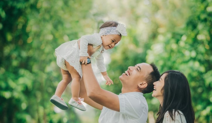 Foto eines glücklichen Elternteils, der sein Baby hält, symbolisch für das Verlängern der Elternzeit.