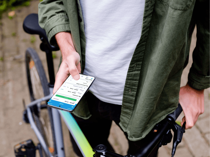 Arbeitsstrukturen: Die Abbildung zeigt Mitarbeitende, die mit einer mobilen App ihre Arbeitszeiten erfassen, während sie hybrid arbeiten. Diese flexible Arbeitsweise ermöglicht es den Arbeitnehmern, sowohl im Büro als auch im Homeoffice ihre Aufgaben effizient zu erledigen und dabei die Work-Life-Balance zu verbessern.