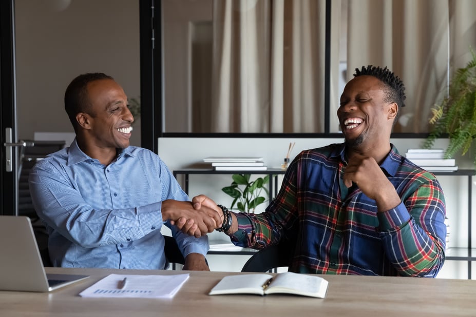 Male employer shaking hands with his employee during a one-on-one meeting